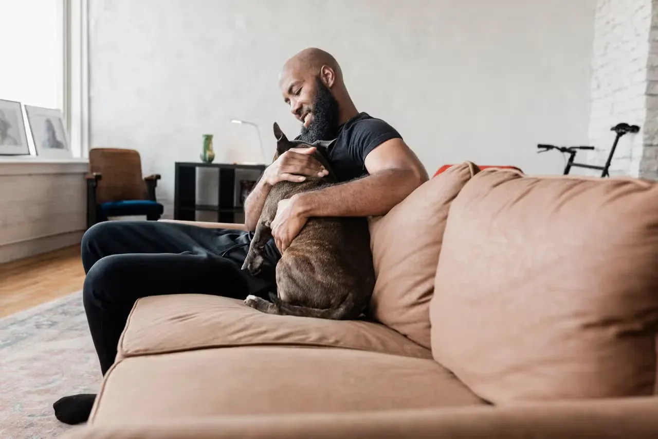 A dog owner protecting their dog and making them feel comforted.