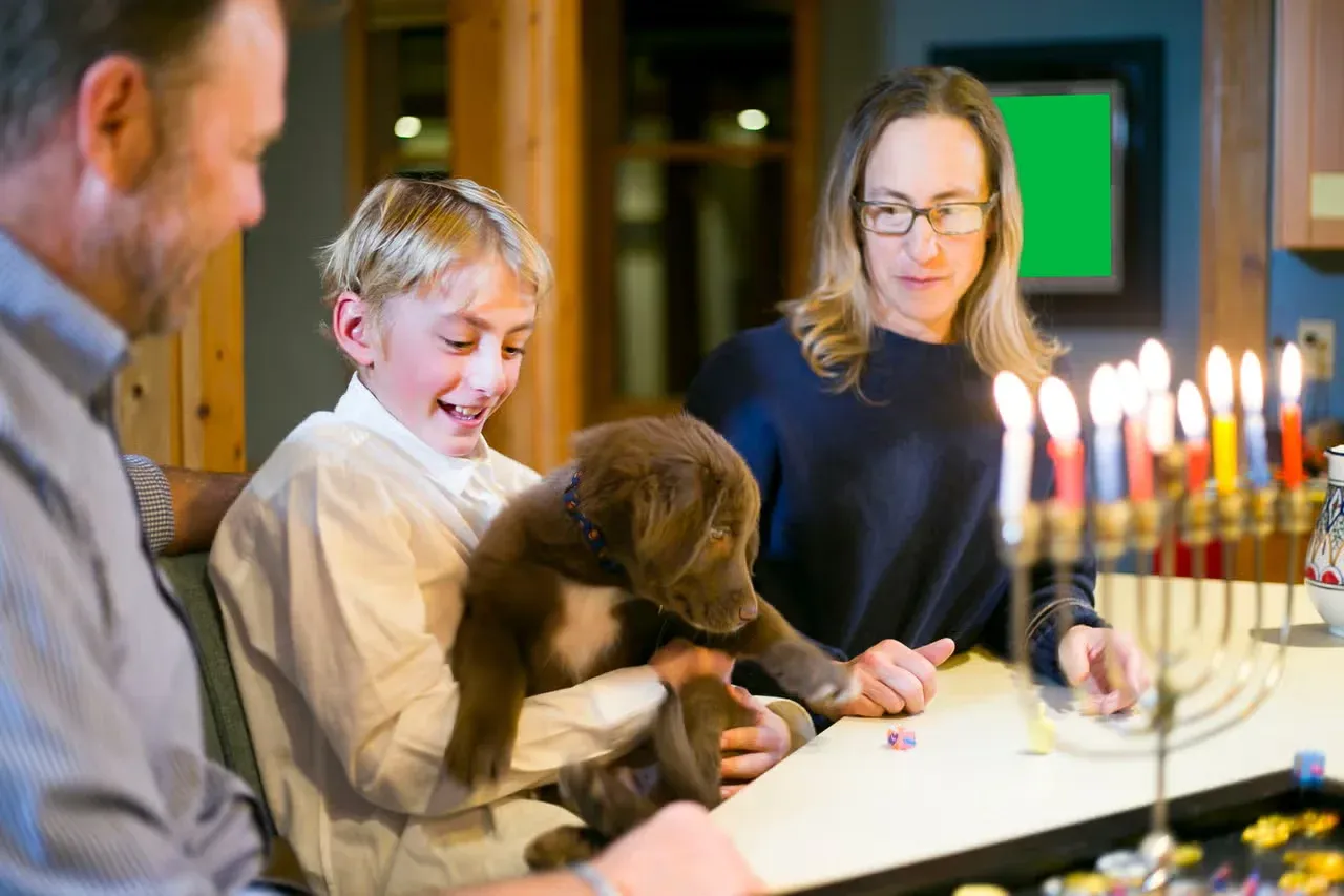 A family celebrating Hanukkah with their Lab.