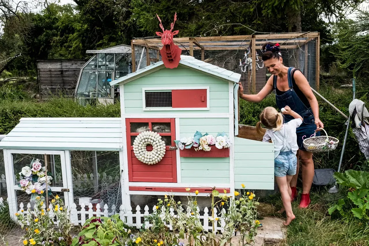 A woman and her daughter collecting eggs from a cute chicken house.