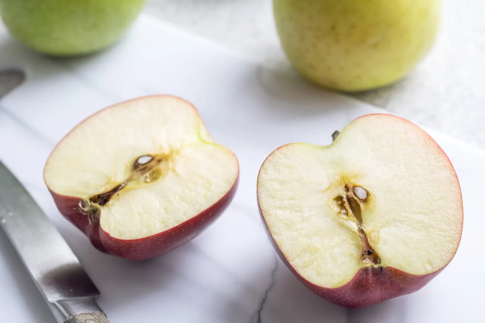 Two halves of a fresh apple cut down the middle.